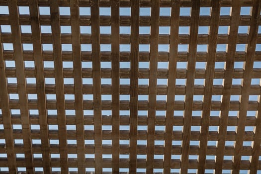 Wooden square grid in color with blue sky.