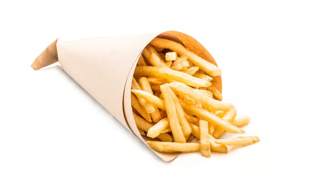 Fresh french fries chips wrapped in brown craft paper on a white background