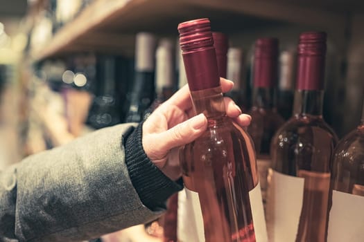 Woman choosing rose wine in market