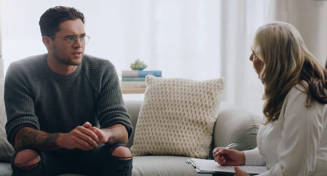 Therapy, man and therapist talking about mental health during a consultation in an office. Depression, communication and psychologist consulting with sad patient about anxiety or problem of the mind.