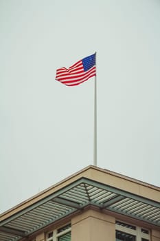 American flag on top of the US Embassy in Berlin on a winter day.