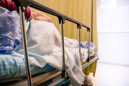 Woman patient lying on a bed in a hospital room.