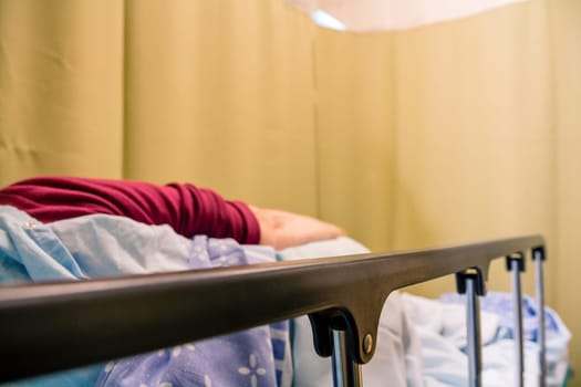 Woman patient lying on a bed in a hospital room.