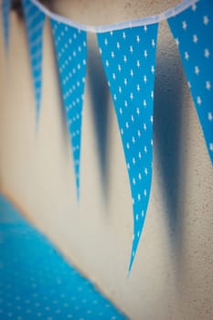 line of colorful blue party decorations flags with white stars illustration hanging from the wall.