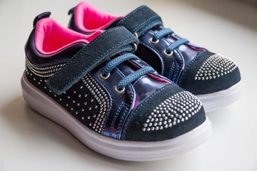 Baby boots, luxury sneakers, sports shoes, boots for girls. Kids trendy footwear with rhinestone decoration. pretty pair of casual baby shoes with a velcro fastening strap.