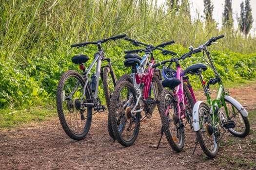 Several bicycles parked on a dirt road.