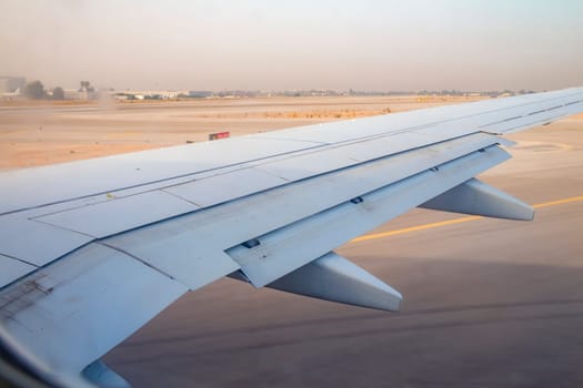 Airplane wing on the runway at ben gurion airport on sunrise
