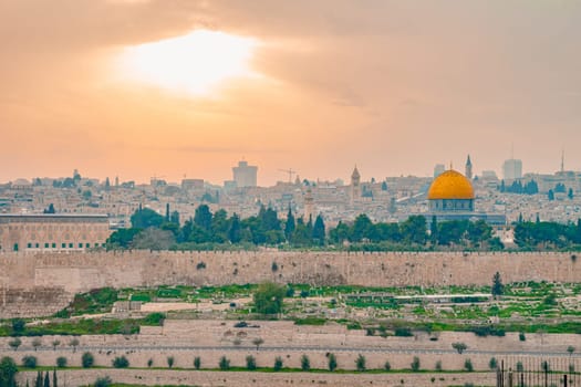 Panoramic view of Jerusalem old city and the Temple Mount during a dramatic colorful sunset. A view of the Dome of the Rock and Al Aqsa Mosque from the Mount of Olives in Jerusalem, Israel.