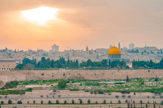 Panoramic view of Jerusalem old city and the Temple Mount during a dramatic colorful sunset. A view of the Dome of the Rock and Al Aqsa Mosque from the Mount of Olives in Jerusalem, Israel.