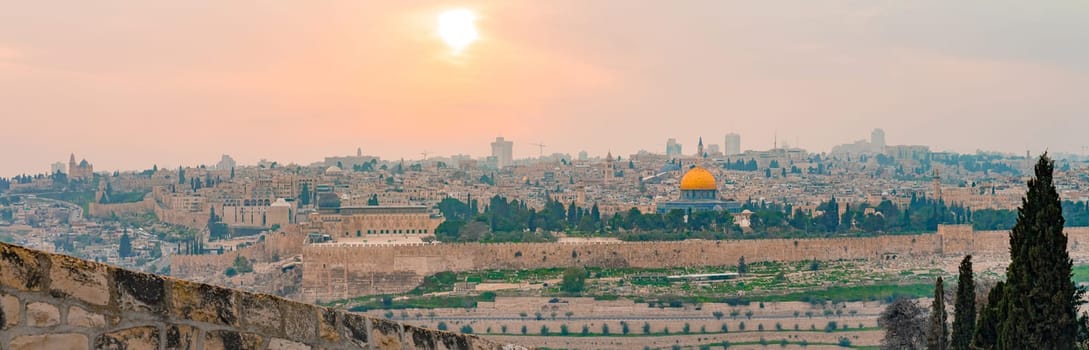 Panoramic view of Jerusalem old city and the Temple Mount during a dramatic colorful sunset. A view of the Dome of the Rock and Al Aqsa Mosque from the Mount of Olives in Jerusalem, Israel.
