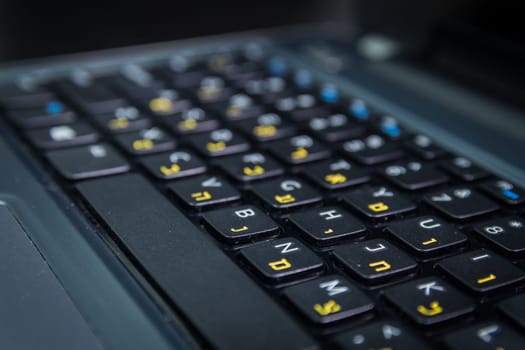 Keyboard with letters in Hebrew and English - Laptop keyboard - Close up - Dark atmosphere