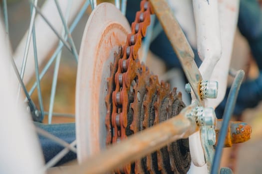 Old rusty chain on white bicycle. Selective focus close up.