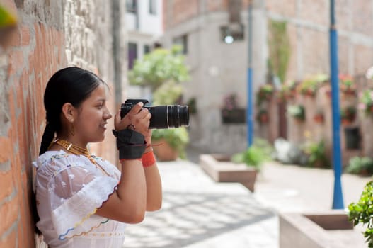 indigenous girl in profile in traditional dress learning to use a reflex camera in a course. High quality photo