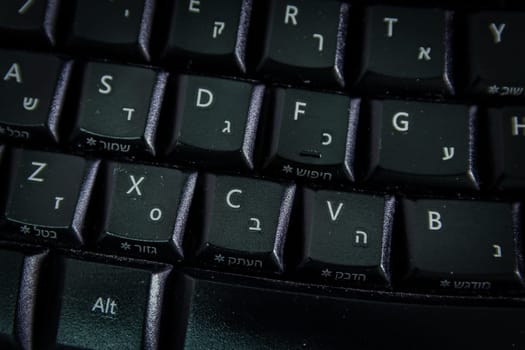 Keyboard with letters in Hebrew and English - Wireless keyboard - Top View - Close up - Dark atmosphere