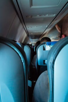 Interior of passenger airplane with people on seats.