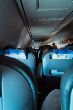 Interior of passenger airplane with people on seats.