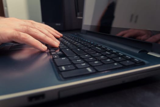 Man typing on a keyboard with letters in Hebrew and English - Laptop keyboard
