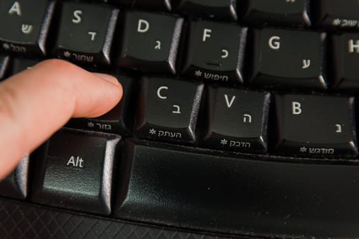 Man typing on a Wireless keyboard with letters in Hebrew and English - Press the Cut button - Top View