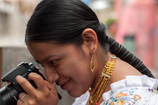 closeup of indigenous girl with reflex camera taking a photo downwards. High quality photo