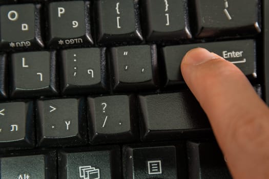 Man typing on a Wireless keyboard with letters in Hebrew and English - Press the Enter key - Top View