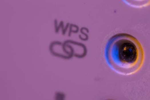 Macro closeup on WPS symbol signal connection status led light. The WiFi repeater device is in electrical socket on the wall. It help to extend wireless network in home or office.