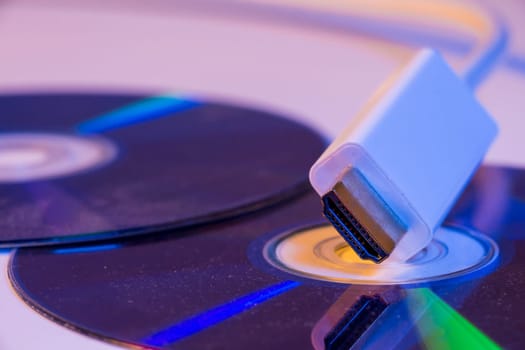 Closeup of white HDMI cable with it's reflection on blank disc.