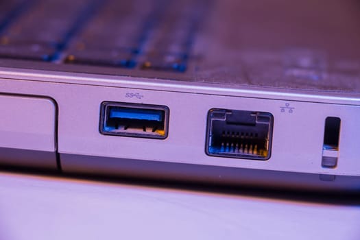 Closeup of Ethernet cable and USB ports in a laptop.