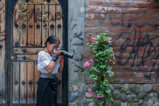 bonita chica indigena aprendiendo fotografia en la calle, sacando fotografia a una planta con flores. High quality photo