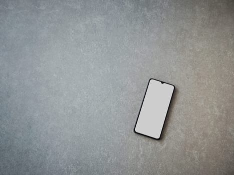 Black mobile smartphone mockup lies on the surface with blank screen isolated on porcelain granite ceramic stone background. Top view flat lay with copy space.