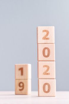 Abstract 2020, 2019 New year target plan design concept - wood blocks cubes on wooden table and pastel blue background, close up, blank copy space.