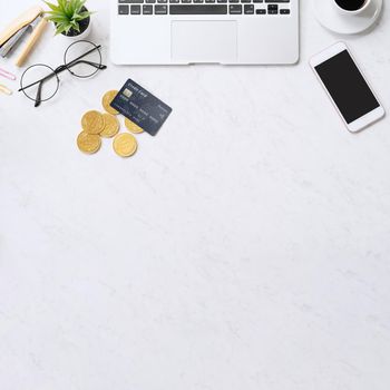 Concept of online payment with credit card with smart phone, laptop computer on office desk on clean bright marble table background, top view, flat lay