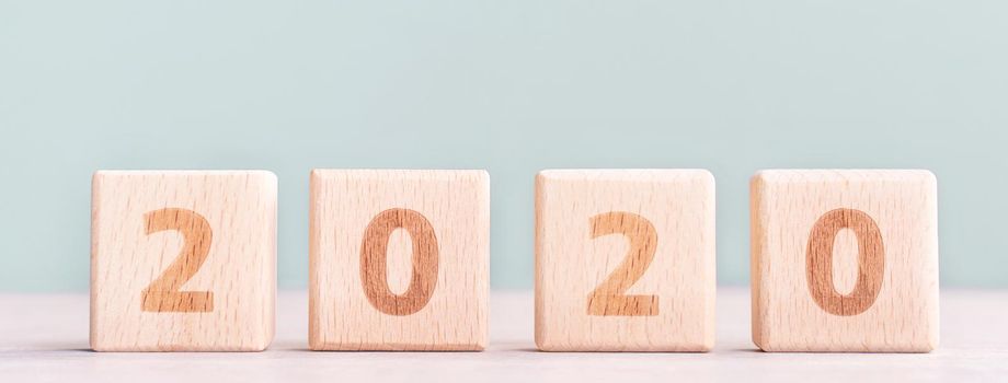 Abstract 2020, 2019 New year target plan design concept - wood blocks cubes on wooden table and pastel green background, close up, blank copy space.