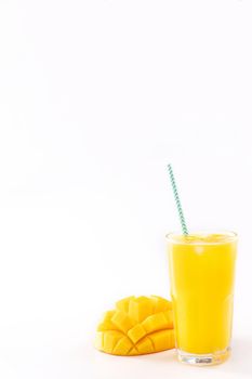 Fresh tropical mango juice with beautiful diced pulp and striped paper straw isolated on white background table, close up, cut out, clipping path.