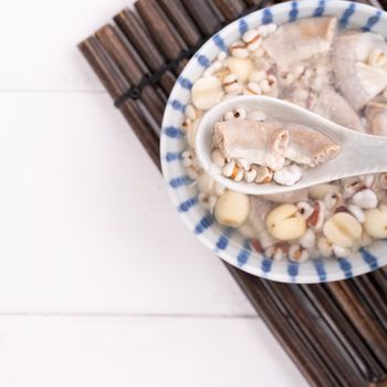 Tasty Four Tonics Herb Flavor Soup,Taiwanese traditional food with herbs,pork intestines on white wooden table,close up,flat lay,top view