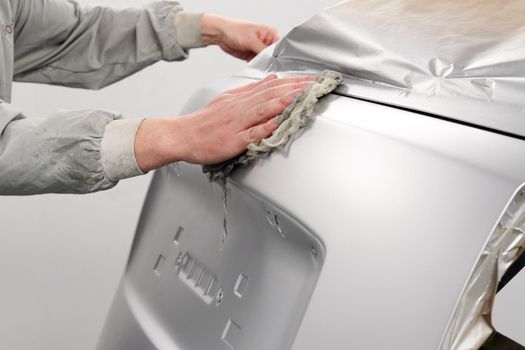 Auto mechanic preparing the car for paint job in painting booth