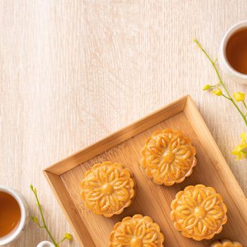 Mid-Autumn Festival holiday concept design of moon cake, mooncakes, tea set on bright wooden table with copy space, top view, flat lay, overhead shot