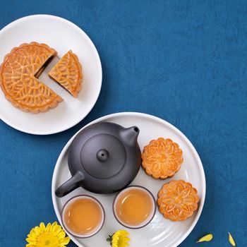 Minimal simplicity layout moon cakes on blue background for Mid-Autumn Festival, creative food design concept, top view, flat lay, copy space.