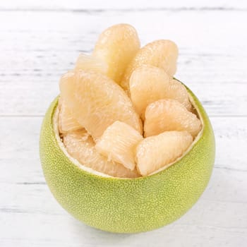 Fresh peeled pomelo, pummelo, grapefruit, shaddock on bright wooden table background. Seasonal fruit for Mid-Autumn Festival, close up, copy space.