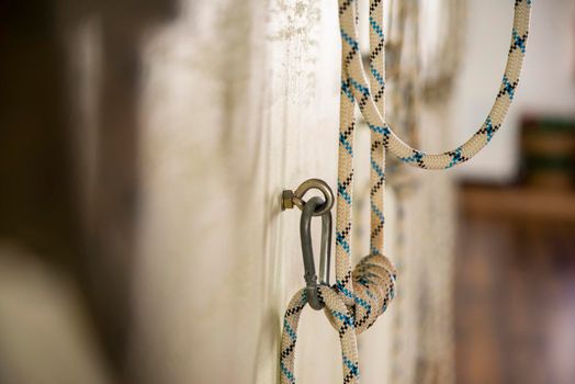 Yoga ropes hanging on studio wall. White background. Iyengar yoga props