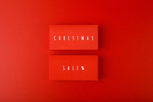 Christmas sale elegant minimal concept in red colors. Christmas sale written on red tablets on red background. 