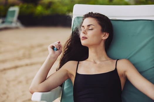 woman holiday relaxation blue lifestyle beach vacation smiling hat tropical sitting chair relax sand ocean girl resort sea beach lying sunbed young