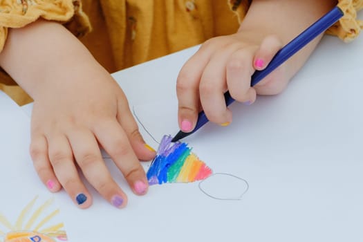 European kid girl painting with colored pencil. Kindergarten children education concept. Close-up of children's drawing.