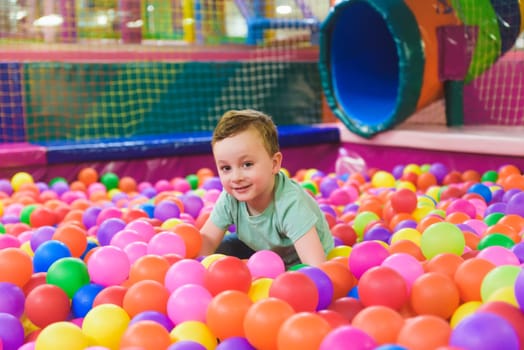 Child on the playground with colored plastic balls.