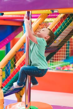 boy on the playground with colored plastic balls.