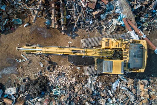 Excavator working in a scrap yard to take care of recyling waste