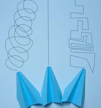 Three paper blue planes with different trajectories, the concept of reaching the goal