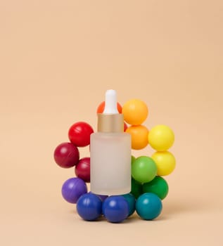 A glass white bottle with a dropper on a beige background, a container for cosmetic products