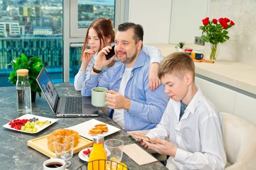 Successful business man having breakfast and working from home. having breakfast with childrens. Distance working, freelancer, distancing at home office.