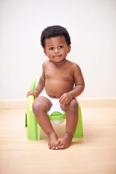 African baby boy, potty training or toilet in home with youth, learning and childhood development on floor. Young toddler, black child or kid sitting in bathroom with diaper, growth and plastic seat.