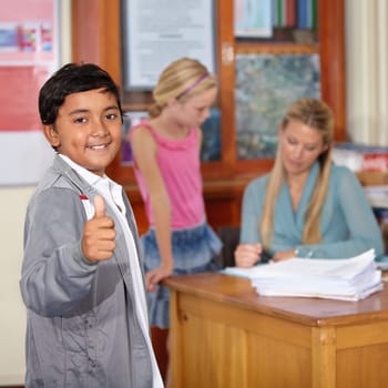 Portrait, child and student with thumbs up, smile and success in classroom. Happiness, hand gesture and kid with like emoji, agreement and approval for learning in elementary school for education